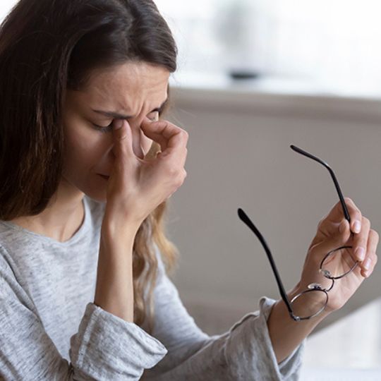 Mulher com dor de cabe&ccedil;a devido &agrave; miopia