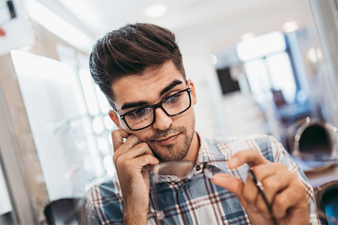 Homem m&iacute;ope a escolher &oacute;culos de corre&ccedil;&atilde;o