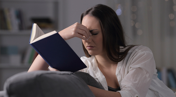 Mulher de olhos fechados em frente a um livro