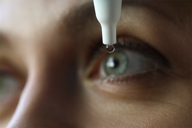 Mulher a utilizar uma solução salina para limpar a prótese ocular
